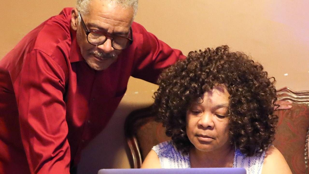 A middle aged couple figuring out finances on their computer at home, spending, expenses, Next Avenue