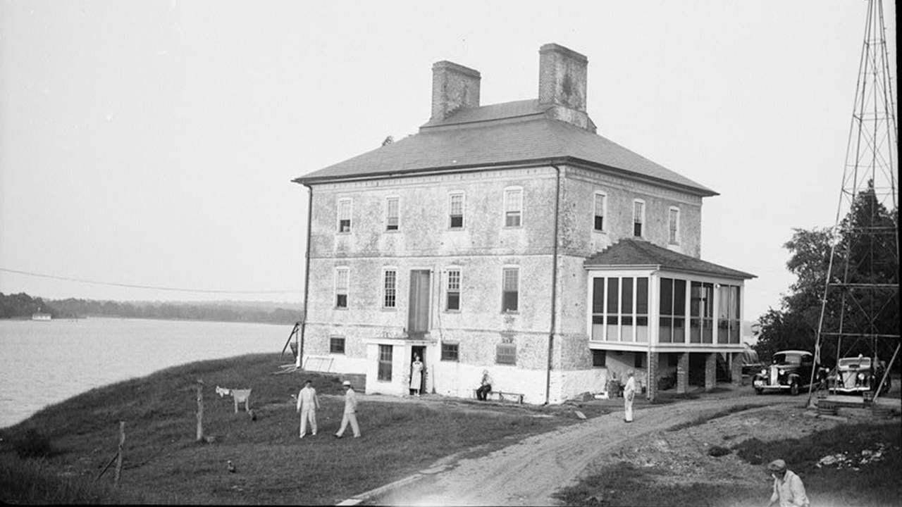 Old photograph of a group home on the water with people outside, history, Next Avenue