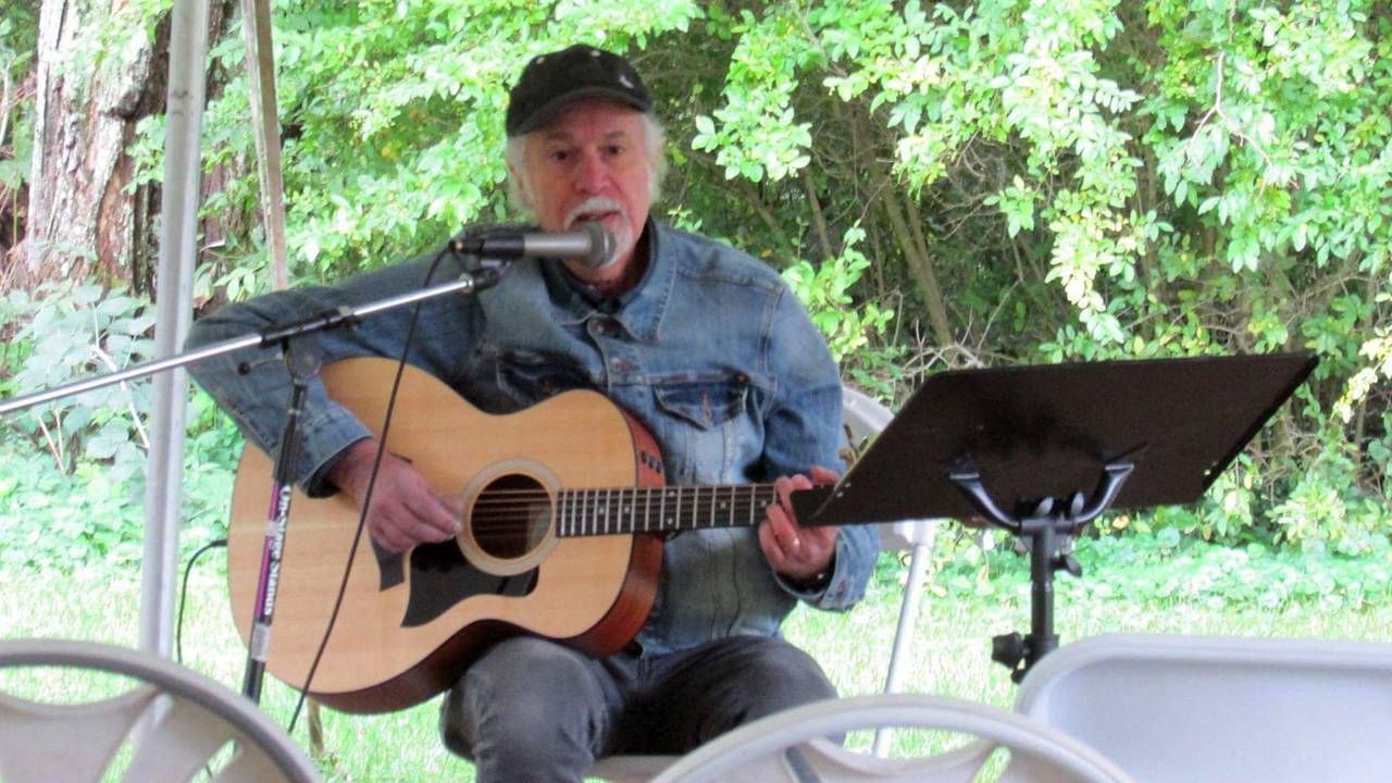Older man playing guitar and singing outside on stage, career change, Next Avenue