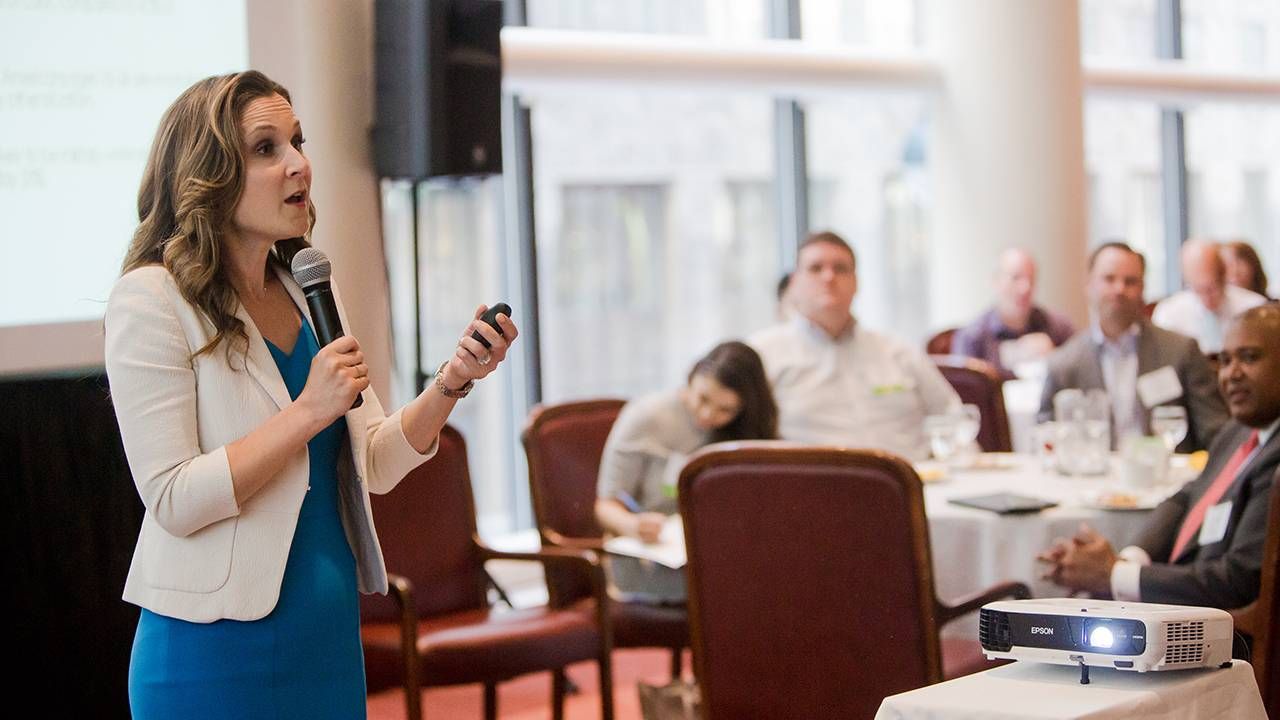 Woman speaking in front of a crowd at conference, career, work, Next Avenue