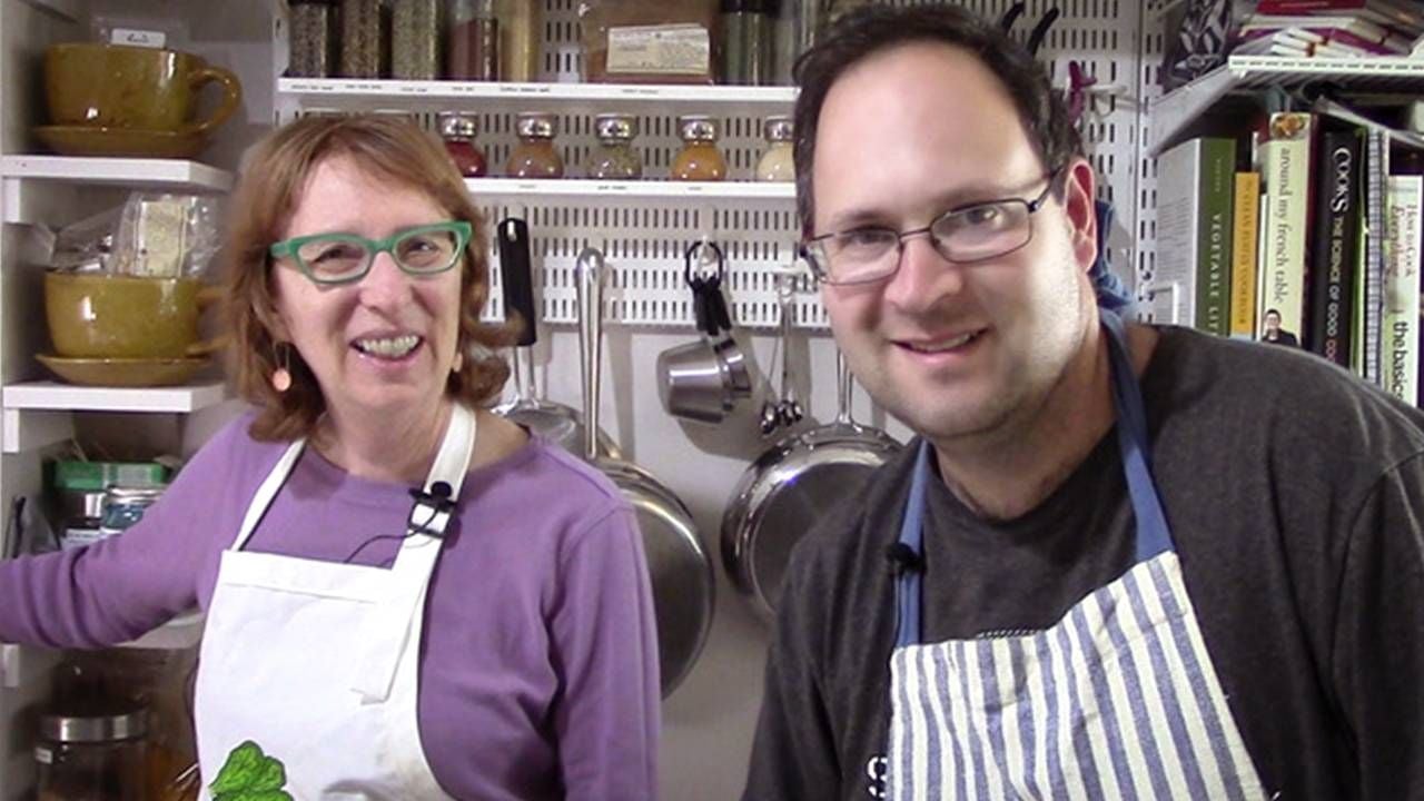 Mother and son wearing aprons cooking together in kitchen, Next Avenue