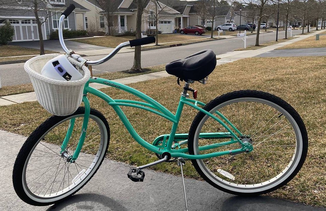 A green bicycle with a white basket outside on a driveway, Next Avenue