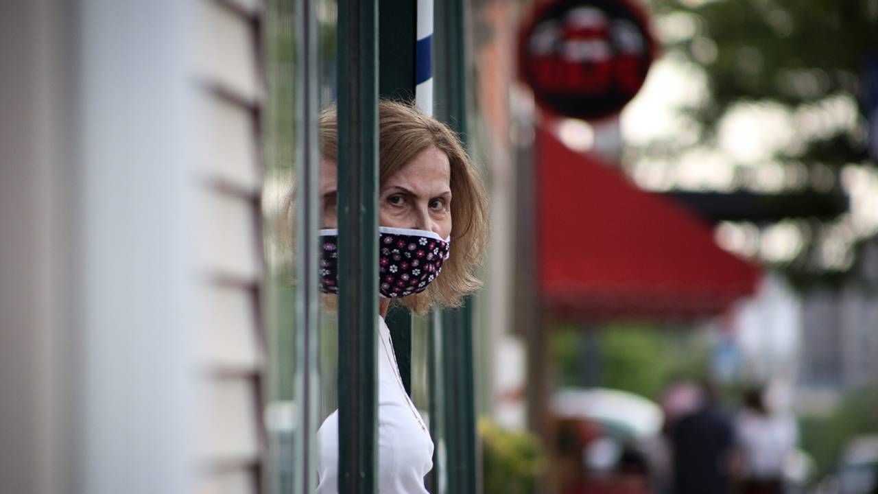 Small business owner standing in the front door of a hair salon, credit cards, Next Avenue