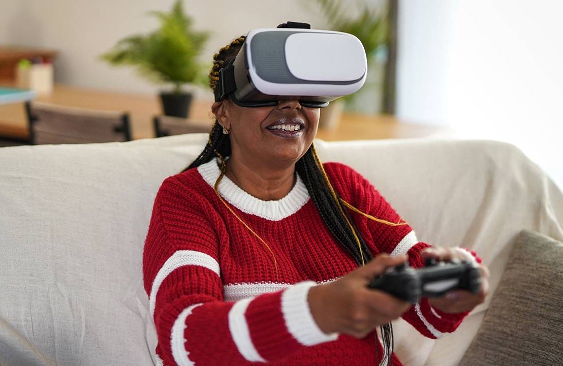 Middle-aged woman playing video games wearing a virtual reality headset, health, dementia, Next Avenue