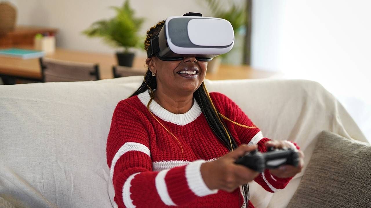 Middle-aged woman playing video games wearing a virtual reality headset, health, dementia, Next Avenue