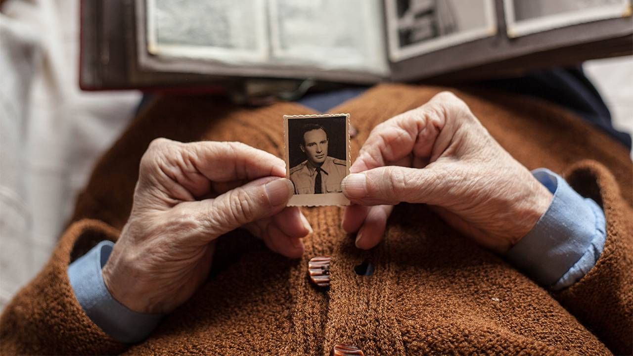 An widow holding an old photo of her late husband. Widows, widowers, estate planning, Next Avenue