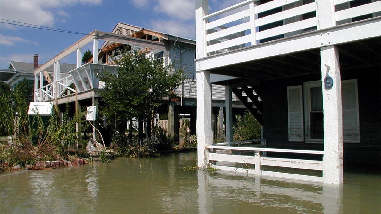 A row of houses on stilts that are heavily flooded, climate change, retirement, Next Avenue