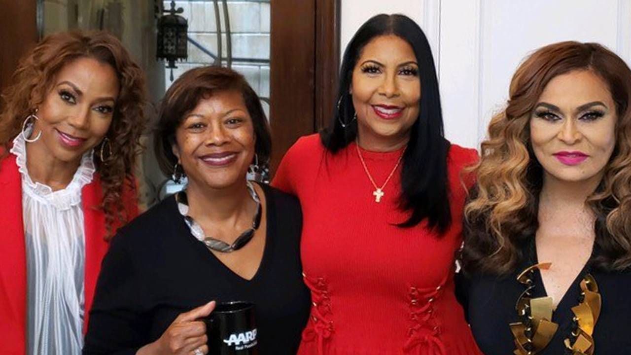 Four women smiling one woman is holding an AARP coffee mug. Diversity, equity, inclusion, Next Avenue