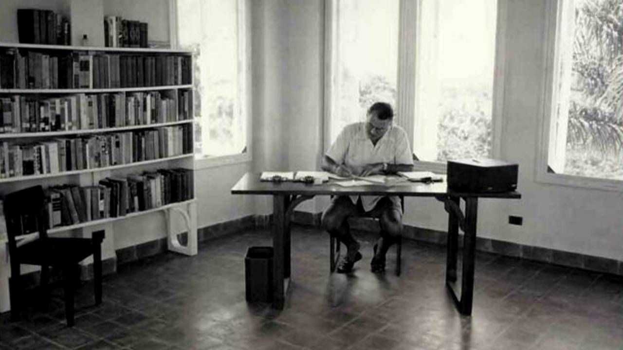 Old photo of Hemingway sitting at his desk, Next Avenue