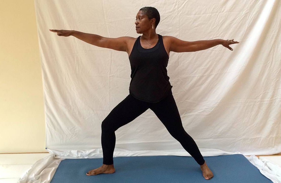 Middle aged woman standing in warrior pose, yoga, Next Avenue