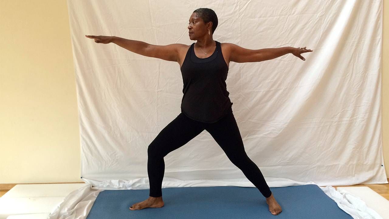 Middle aged woman standing in warrior pose, yoga, Next Avenue