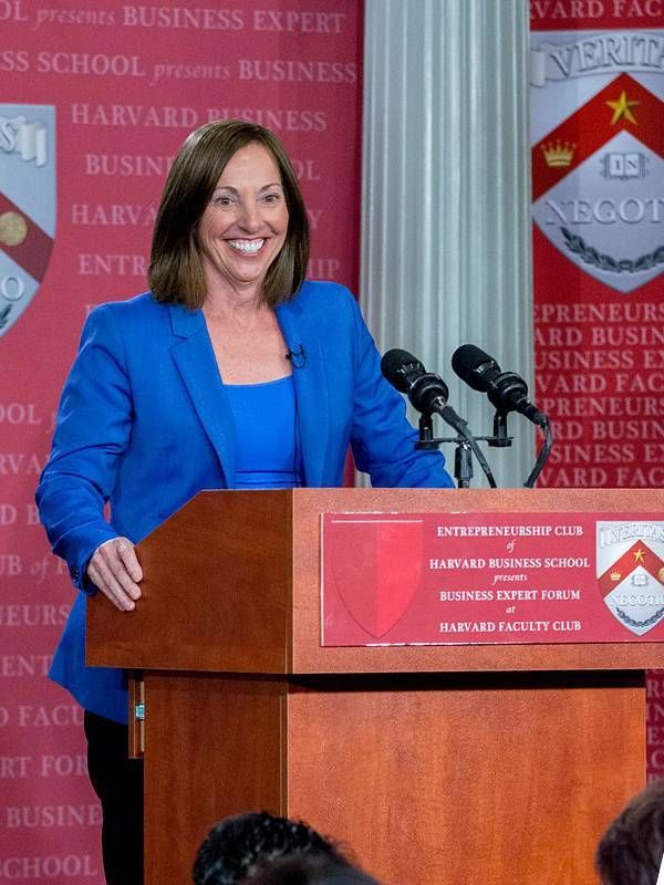 A woman wearing a bright blue suit speaking at a podium. Age independently, Next Avenue