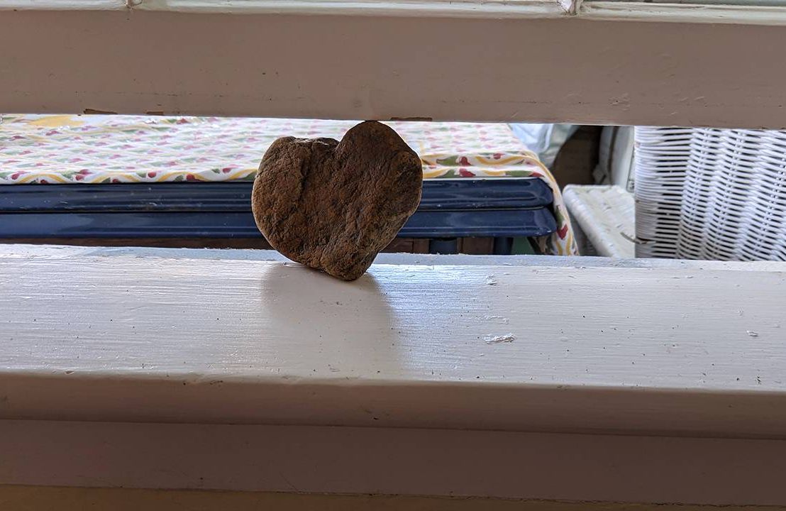 The author props her window open with a heart shaped rock, house, home, Next Avenue