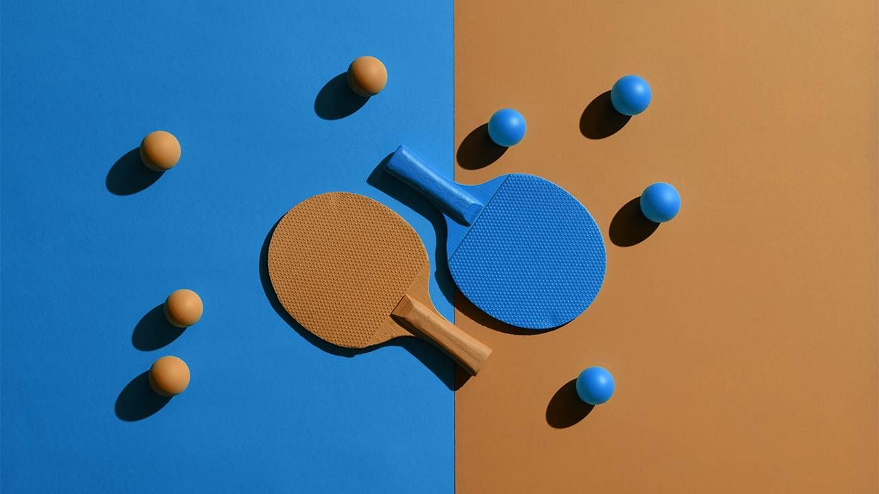 Orange and blue pingpong paddles and balls on a pingpong table. Marriage tension, Next Avenue