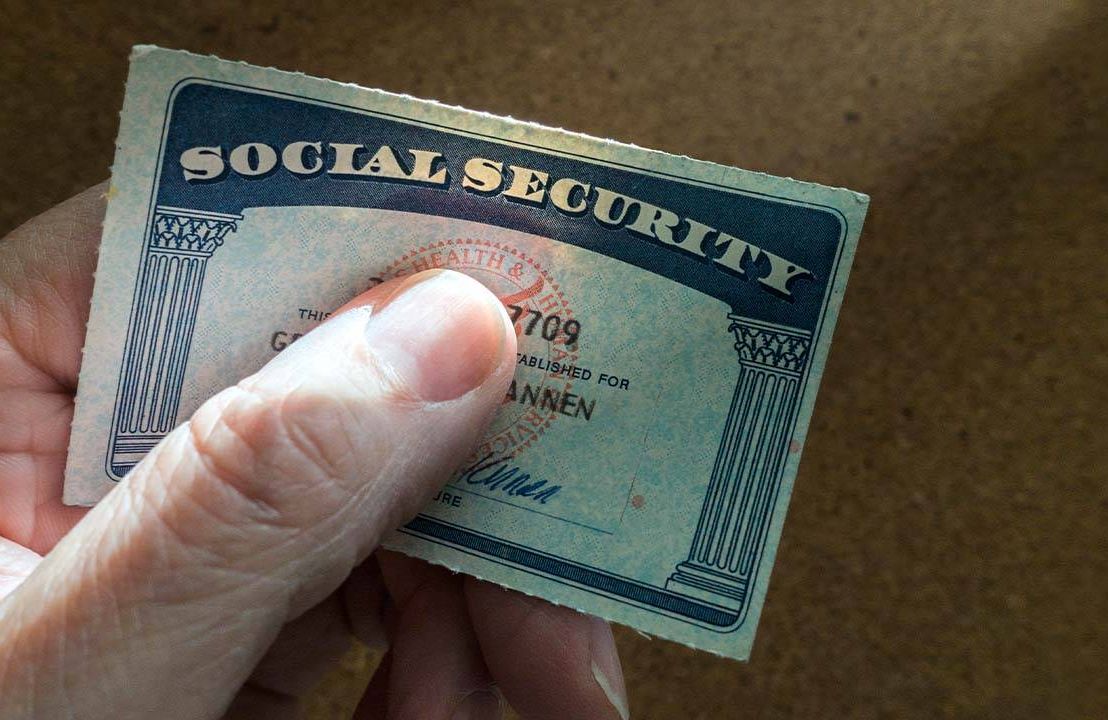 Close up of a hand holding a social security card.