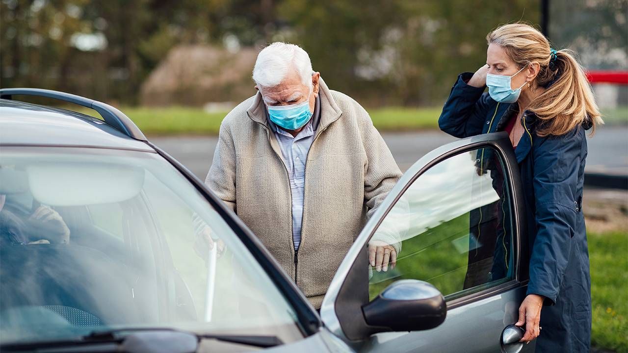 Caregiver and daughter helping her dad into the car. Family caregiver, paid family leave, Next Avenue