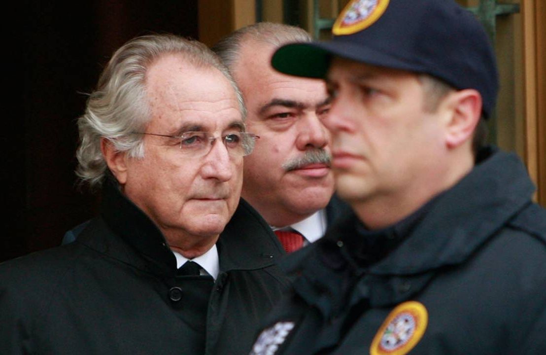 Bernie Madoff being escorted by two police officers. Madoff Talks, small investors, Next Avenue