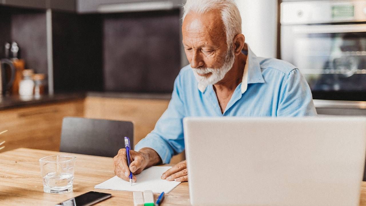 An older man making a checklist of questions. Next Avenue