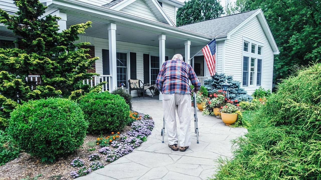 An older man walking up a ramp to his front door with a walker. Aging in place plan, age in place, Next Avenue