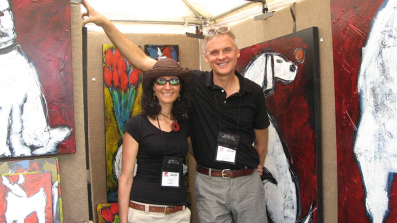The author and her husband posing at their art booth in front of paintings. Art Festivals, Art, Next Avenue