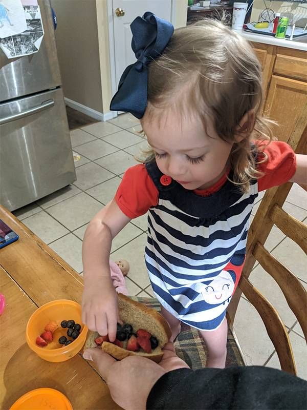 A young grandchild eats a fruit sandwich. Family, cookbook, recipes, Next Avenue