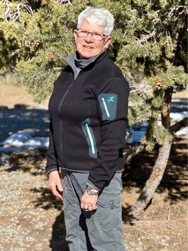 A woman stanfing outside wearing hiking gear. LGBTQ senior housing communities, LGBTQ seniors, Next Avenue