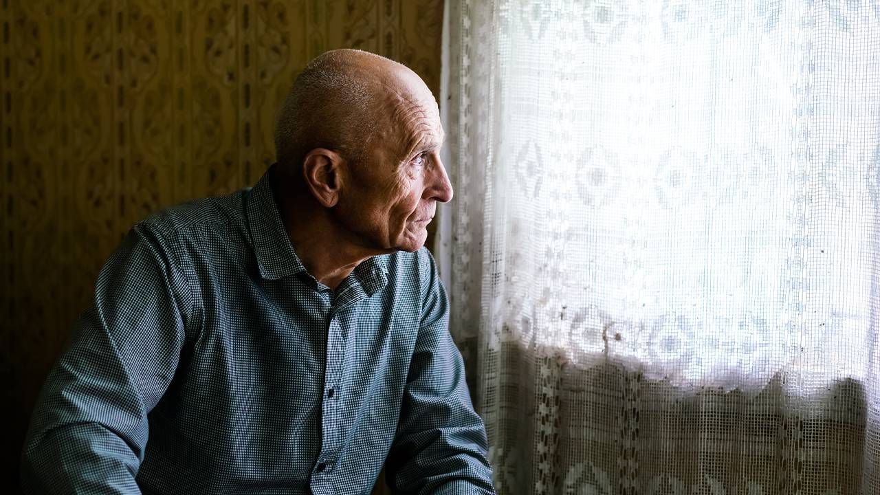 An older man looking pensive out of the window. Retirement pitfalls, retirement plan, Next Avenue