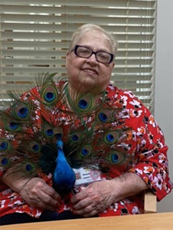 An older woman and PACE recipient holds a peacock statue. Home care, Next Avenue