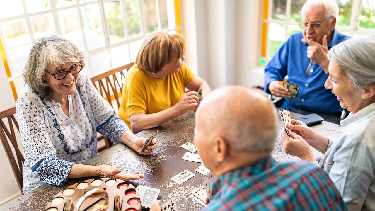 a group of older adults sit around a table talking