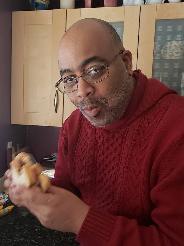 Author Adrian Miller taking a bite of a BBQ sandwich. Barbecue, African American Black cooks, Next Avenue