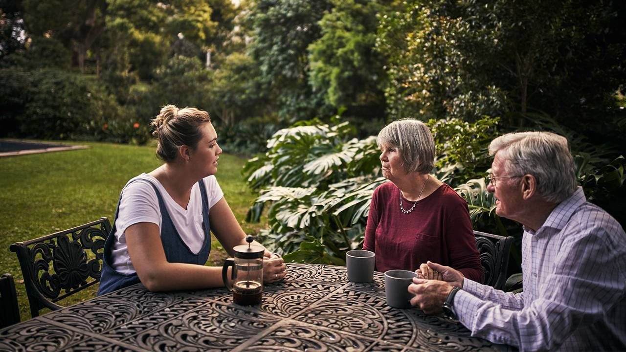 An adult child talking with her parents outside. communication, aging parents, Next Avenue