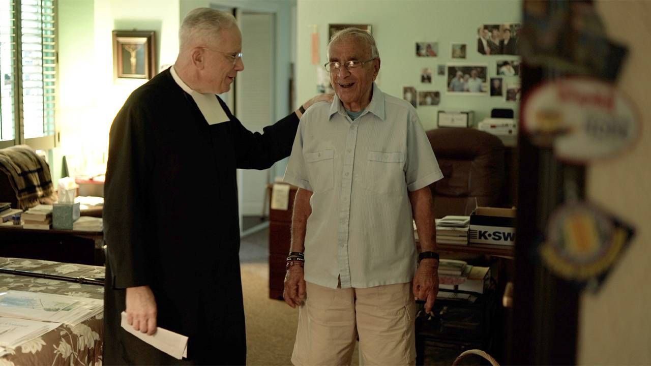 A priest and an older man standing next to eachother. Caregiver, Next Avenue, It's not a burden, caregiving