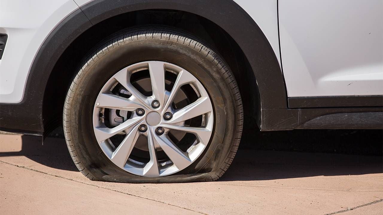 A closeup of a car with a flat tire on the road. First flat tire, Next Avenue