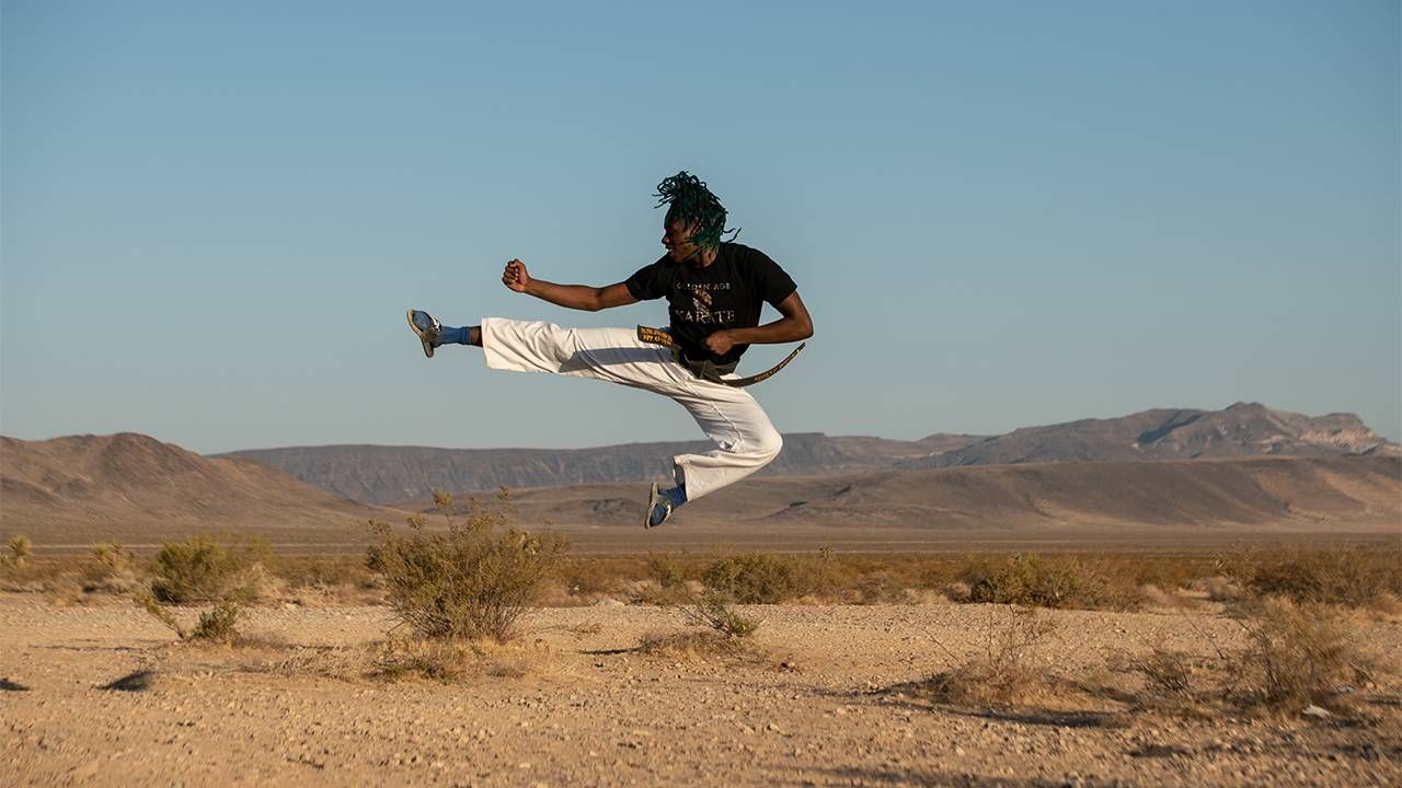 A man doing a high karate kick in the desert. UnLonely Film Festival, Next Avenue