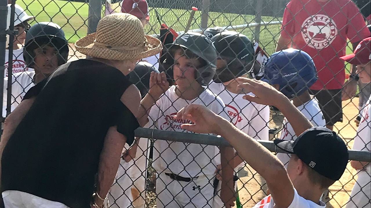 Grandmother talking to her grandson during baseball game. Grandparents, hockey, Next Avenue