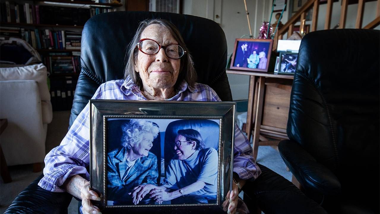 The LGBTQ activist holdng a framed photo of her and her wife.  Lyon Martin house, lesbian activists, Phyllis Lyon, Del Martin, Next Avenue