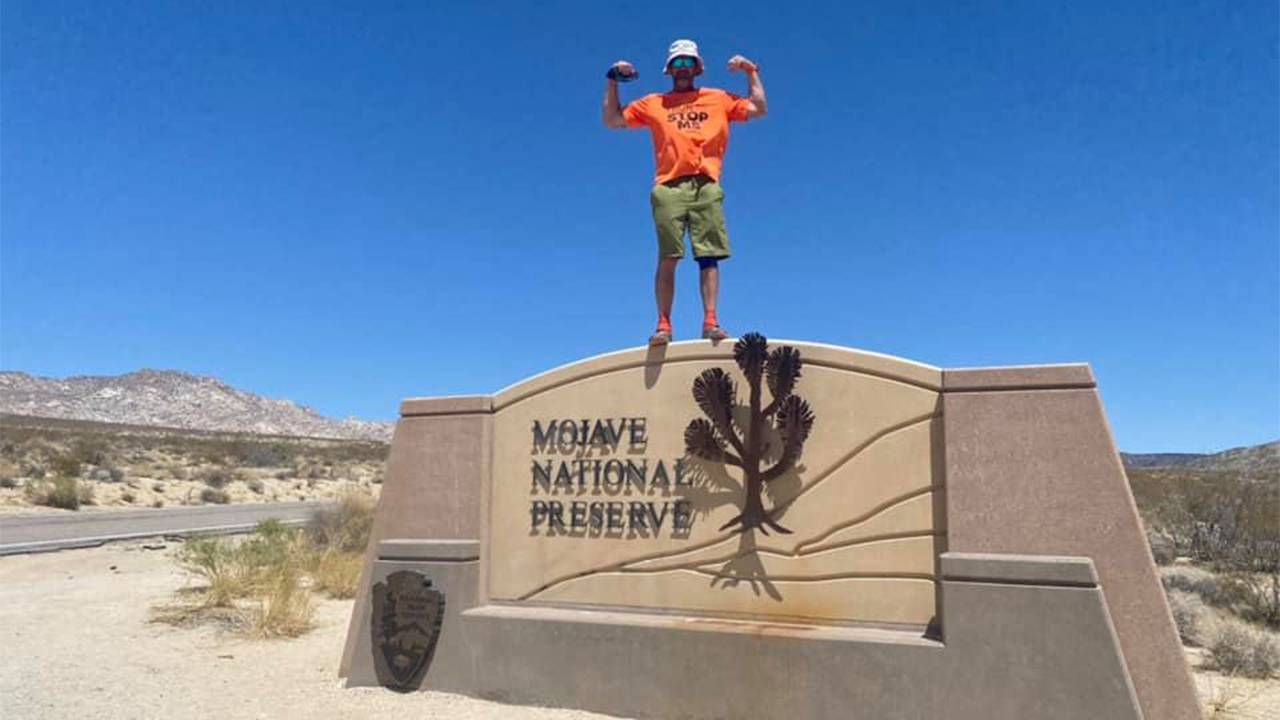 A man standing on top of a large "Mojave Desert" landmark. Running, Next Avenue