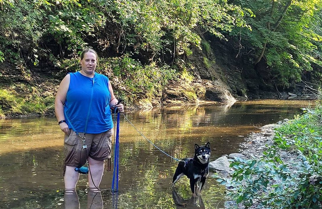 A woman and her dog standing in a creek. Dogs, aging, Next Avenue