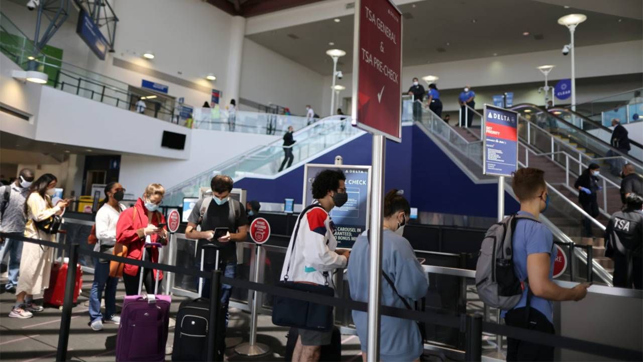 A group of people waiting in line at an airport. New normal, economy, economic, COVID-19 pandemic, Next Avenue