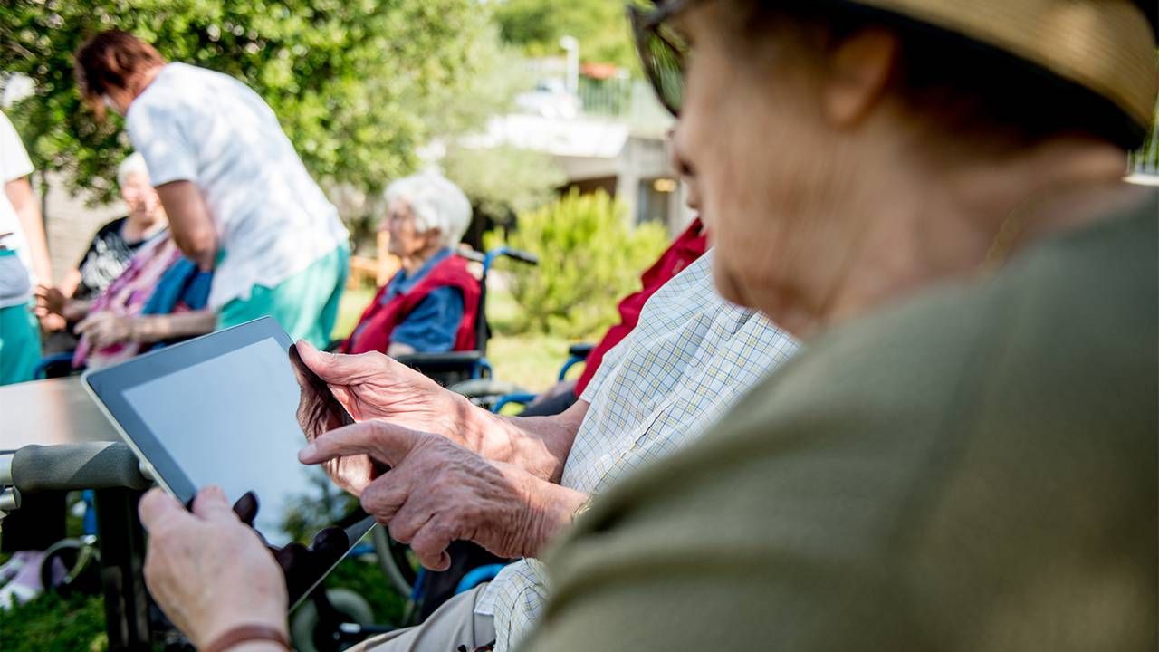 older adults at a nursing home using an ipad to connect.