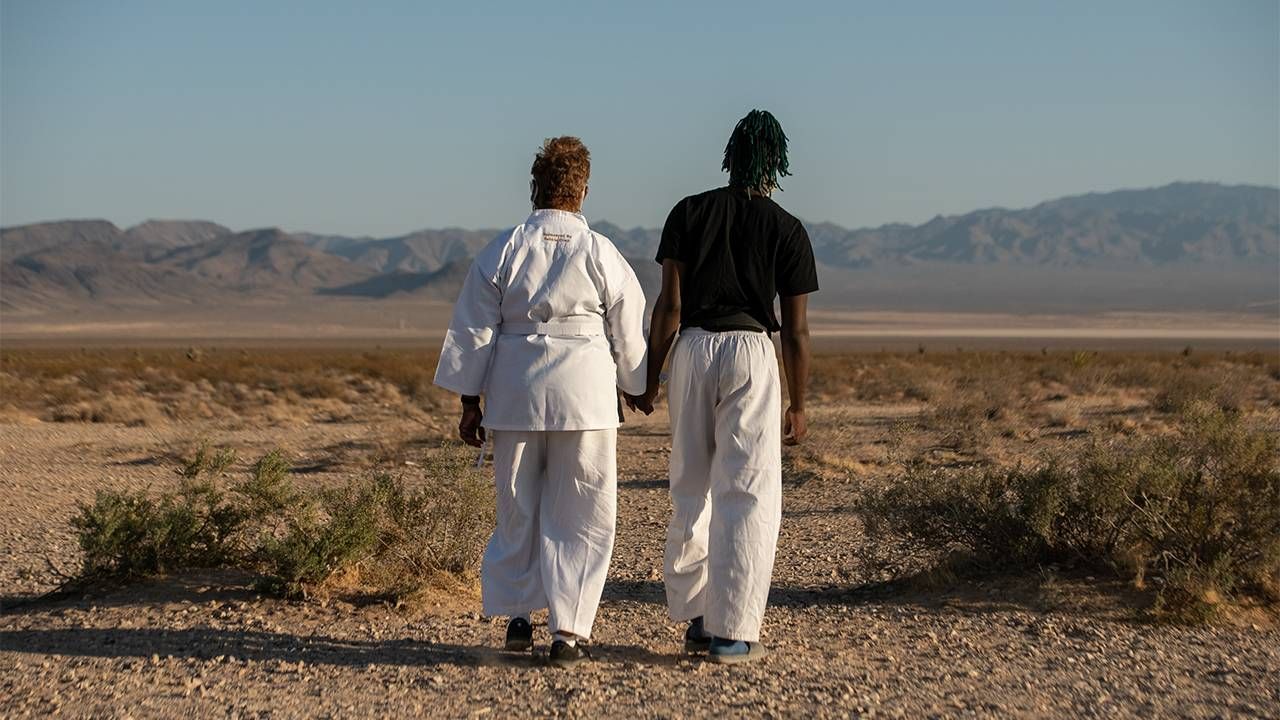 A grandson and his grandma walking in the desert wearing karate gear. Next Avenue