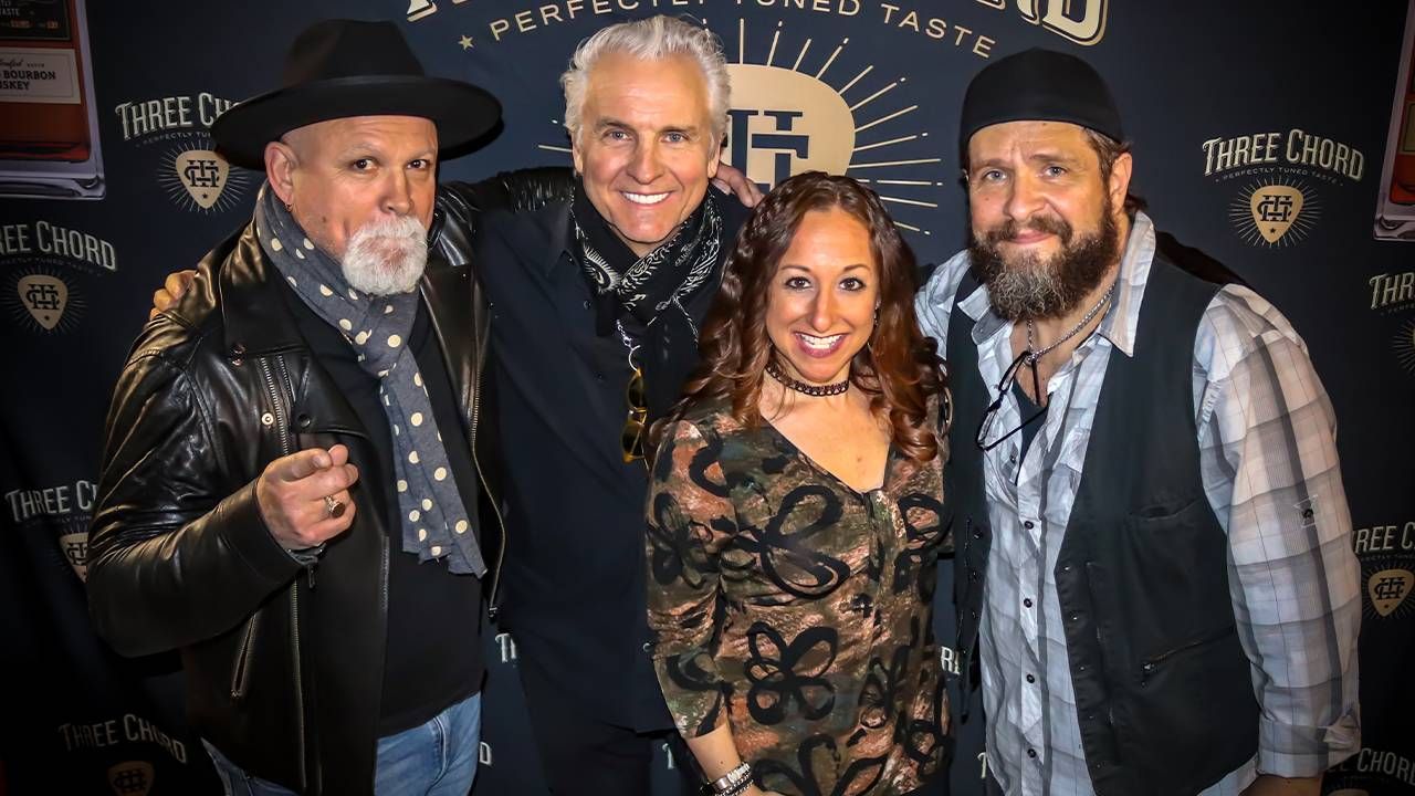 Neil Giraldo and three other musicians in front of a black background. musicians, music, Next Avenue, Three Chord Bourbon