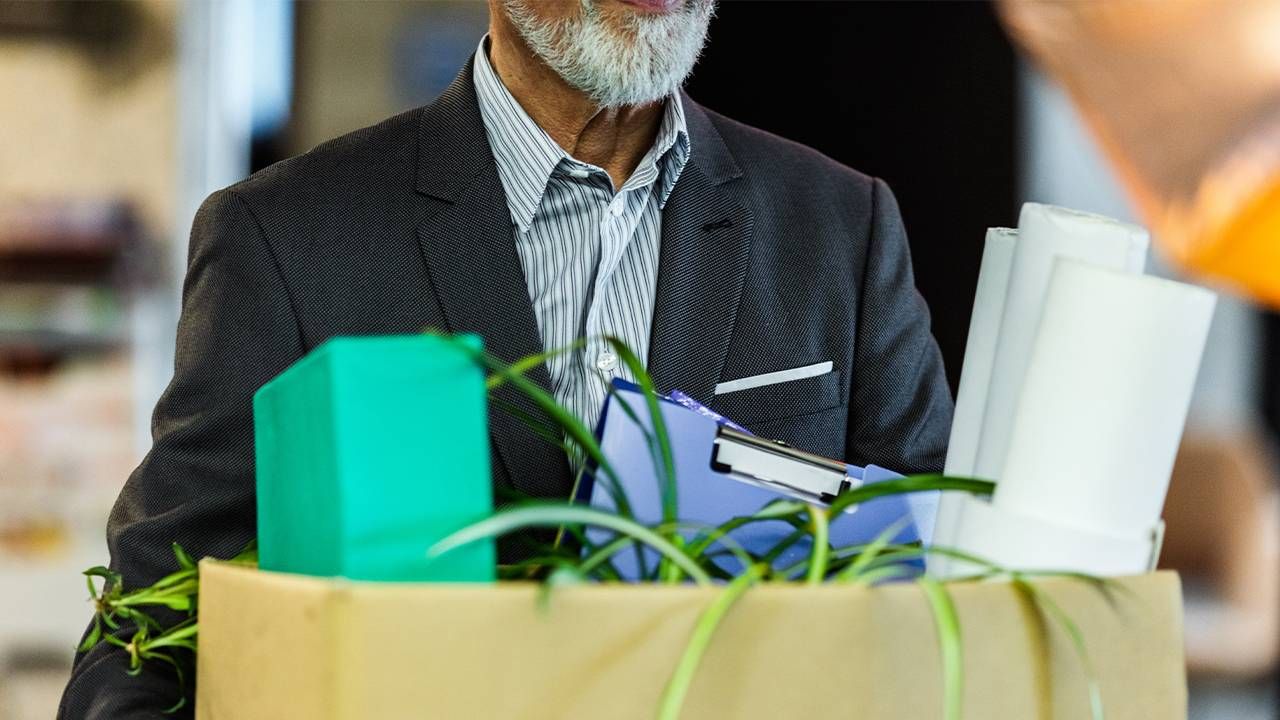 An older worker holding a box of things from his desk. Next Avenue, the big quit, older workers