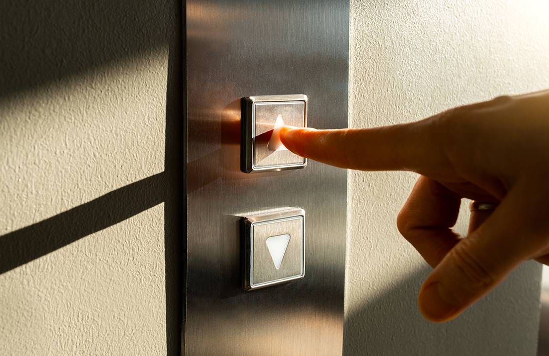 A person's finger pushing an elevator button. Retirement, pitch, Next Avenue