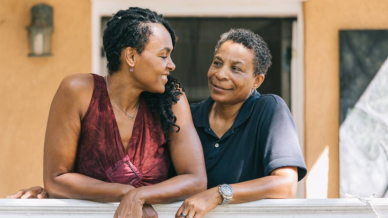 An LGBTQ couple smiling at eachother, LGBTQ housing, Next Avenue