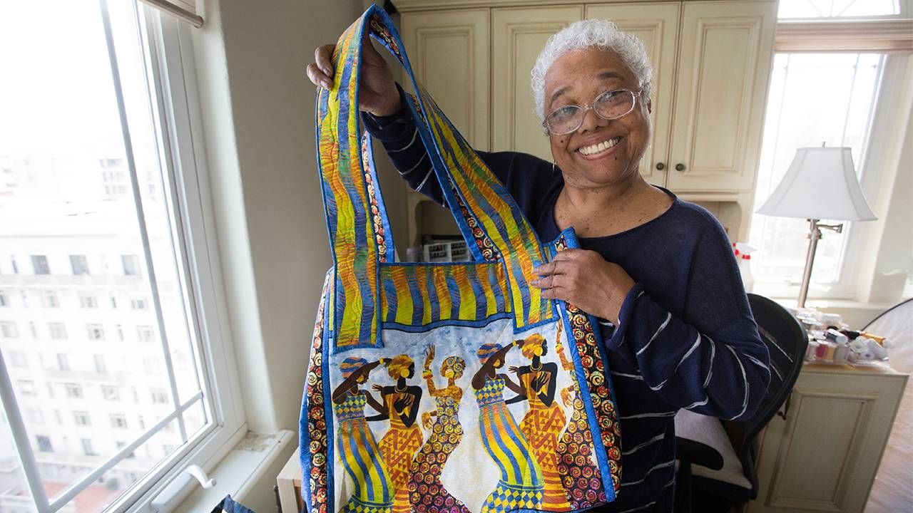 Blanche Brown holding up a quilted bag. Next Avenue, Lives Well Lived Documentary