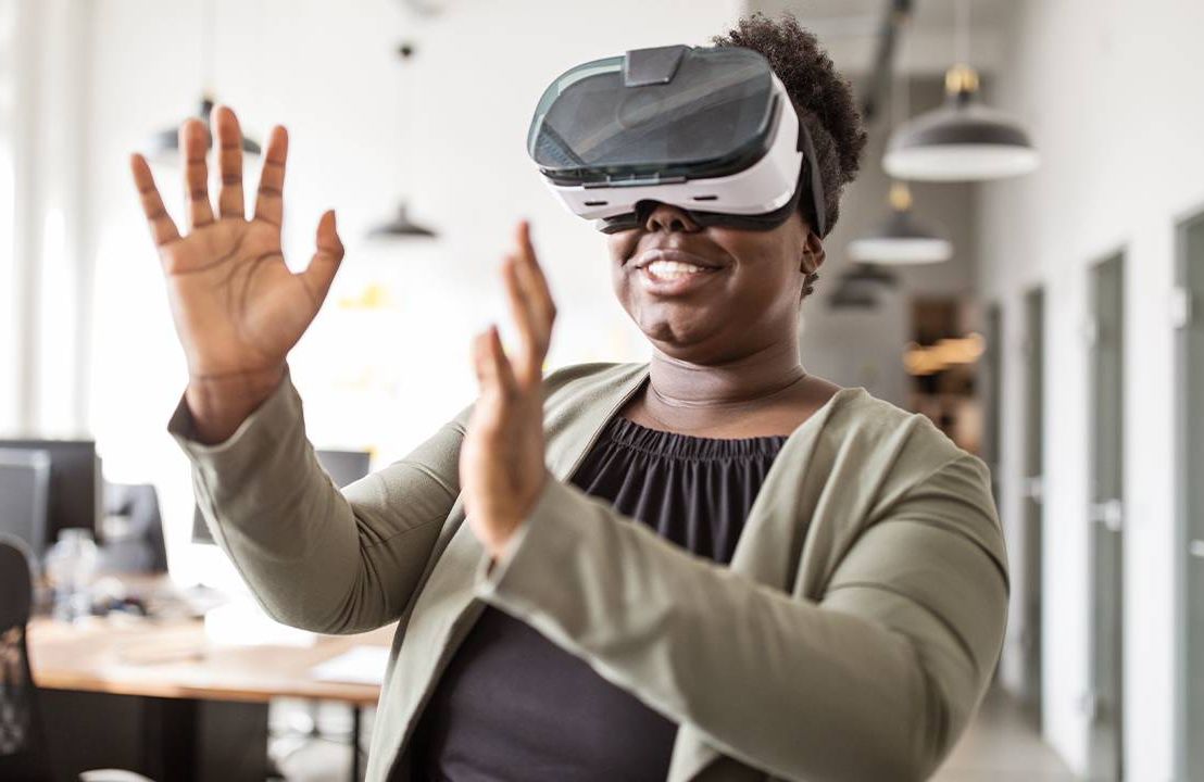 A woman standing up wearing a VR headset. Next Avenue, virtual reality