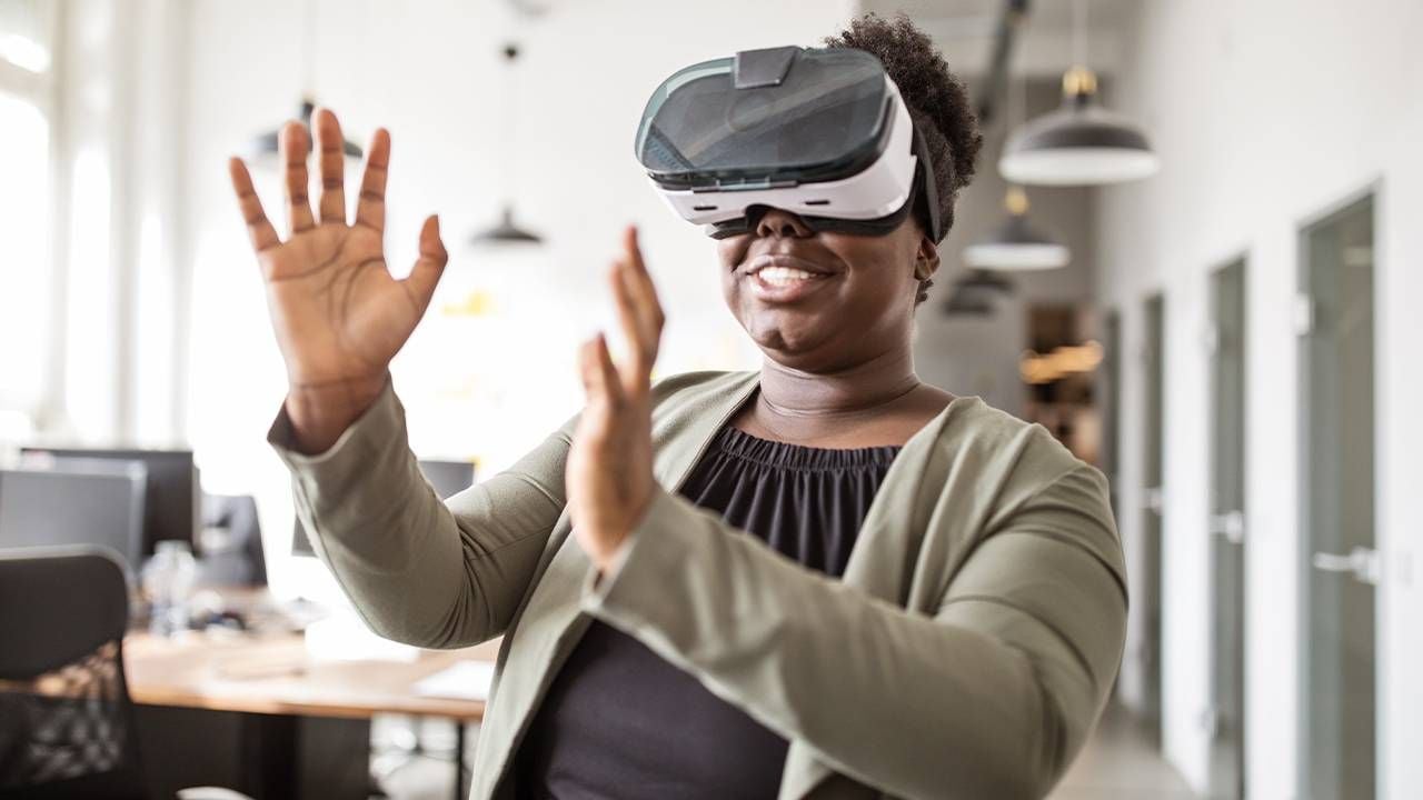 A woman standing up wearing a VR headset. Next Avenue, virtual reality