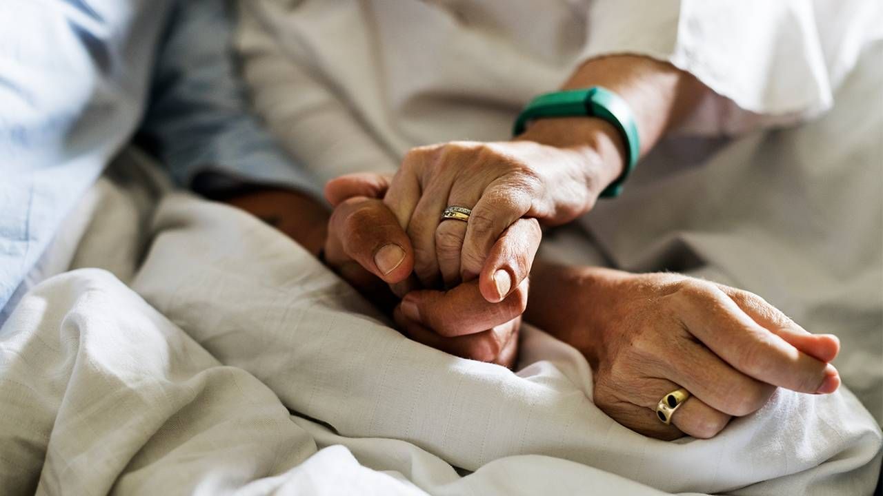 A wife holding hands with her husband in hospice. Next Avenue, VSED, Voluntarily Stopping Eating and Drinking, end of life