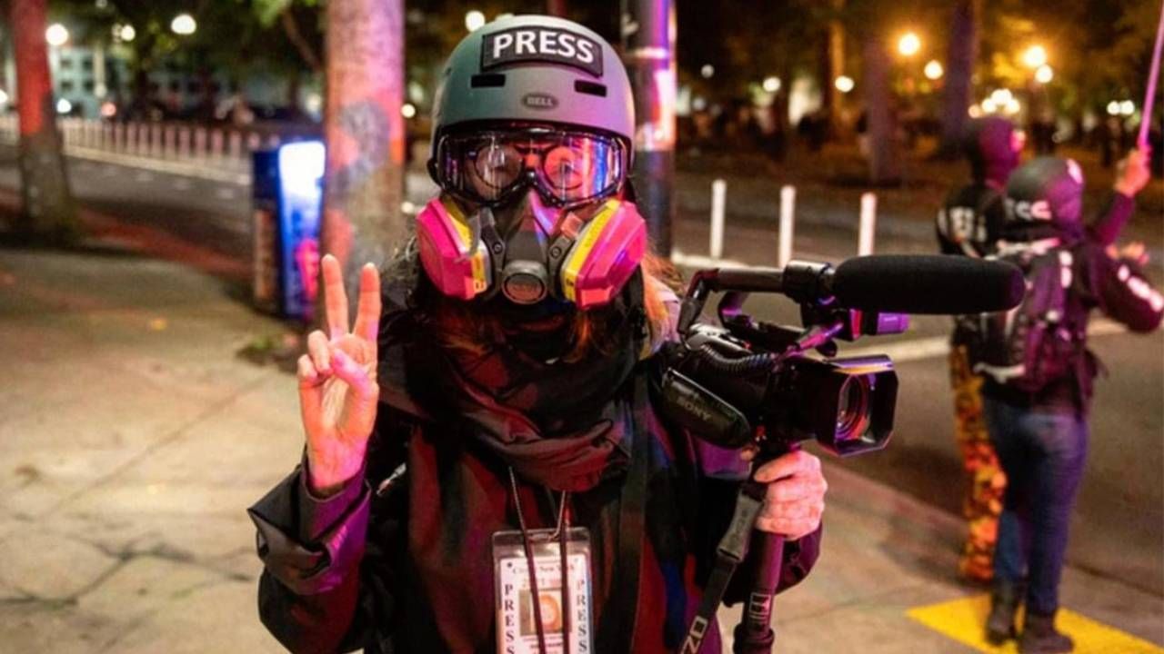 Sandi Bachom wearing a helmet and gas mask while covering protests. Next Avenue, documentary filmmaker